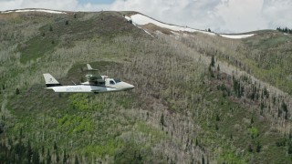 AX140_147 - 5.5K aerial stock footage of aTecnam P2006T passing by green and purple mountains, aspen trees in the Wasatch Range, Utah