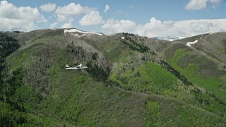 AX140_148E - 5.5K aerial stock footage tracking Tecnam P2006T airplane flying by green and purple mountains, aspen trees, Wasatch Range, Utah