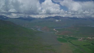 AX140_157 - 5.5K aerial stock footage of Tecnam P2006T flying near reservoir and green mountains, Deer Creek Reservoir, Utah
