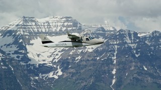 AX140_160E - 5.5K aerial stock footage of tracking a Tecnam P2006T flying by snow-capped Mount Timpanogos, Utah