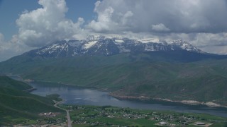 AX140_175 - 5.5K aerial stock footage of homes by Deer Creek Reservoir, and snow-capped Mount Timpanogos, Utah