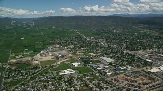 AX140_176E - 5.5K aerial stock footage of approaching small town, pan across neighborhoods, Heber City, Utah