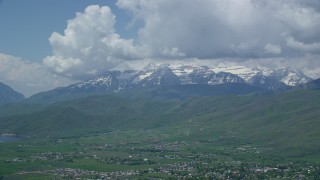 AX140_183 - 5.5K aerial stock footage of snow-capped Mount Timpanogos seen from town of Midway, Utah