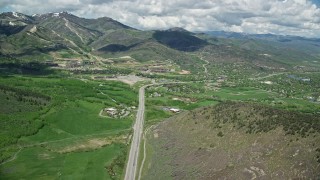AX140_207E - 5.5K aerial stock footage follow State Route 224 to approach Canyons Resort and Park City neighborhoods, Utah