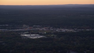 AX141_004 - 5.5K aerial stock footage flying by shopping center, trees, Dedham, Massachusetts, twilight