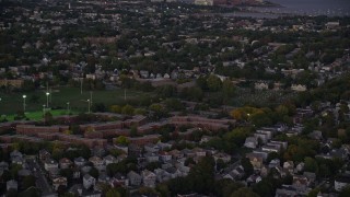 AX141_007 - 5.5K aerial stock footage approaching apartment buildings, Dorchester Center, Boston, Massachusetts, twilight