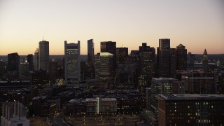 AX141_020 - 5.5K aerial stock footage flying by buildings, city streets, skyline, Downtown Boston, Massachusetts, twilight