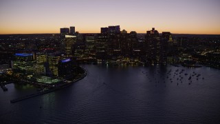AX141_044E - 5.5K aerial stock footage flying by the skyline from over the harbor, Downtown Boston, Massachusetts, twilight