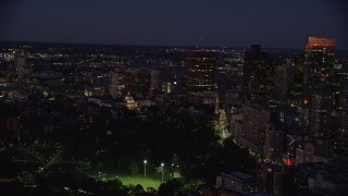 AX141_056E - 5.5K aerial stock footage flying by Massachusetts State House, skyscrapers, Downtown Boston, Massachusetts, night