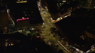 AX141_102E - 5.5K aerial stock footage approaching Harvard Square, Massachusetts Avenue, Harvard University, Massachusetts, night
