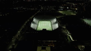 AX141_106 - 5.5K aerial stock footage approaching a well-lit Harvard Stadium, tilt down, Harvard University, Massachusetts, night