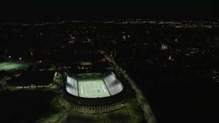 AX141_109E - 5.5K aerial stock footage flying by Harvard Stadium and bridges, Harvard University, Massachusetts, night