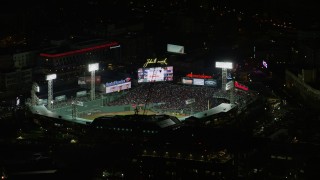 AX141_132 - 5.5K stock footage aerial video flying closely by baseball game at Fenway Park, Boston, Massachusetts, night