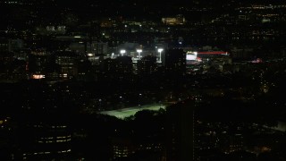 AX141_134 - 5.5K aerial stock footage flying by buildings, skyscrapers, baseball game at Fenway Park, Boston, Massachusetts, night