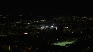 AX141_135E - 5.5K aerial stock footage flying by downtown buildings, Fenway Park, Boston, Massachusetts, night