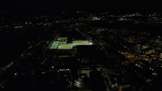 AX141_169 - 5.5K aerial stock footage approaching sports fields and Massachusetts Institute of Technology, Cambridge, Massachusetts, night