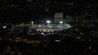 AX141_170E - 5.5K aerial stock footage flying by bright lights of baseball game, Fenway Park, Boston, Massachusetts, night