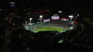 AX141_180 - 5.5K aerial stock footage flying away from baseball game, Fenway Park, Boston, Massachusetts, night