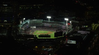 AX141_186E - 5.5K aerial stock footage orbiting a crowded baseball game, Fenway Park, Boston, Massachusetts, night