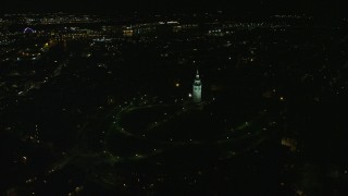 AX141_223E - 5.5K aerial stock footage orbiting Dorchester Heights Monument, reveal skyline, South Boston, Downtown Boston, Massachusetts, night