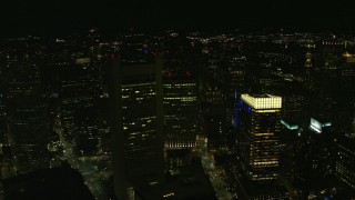 AX141_235E - 5.5K aerial stock footage approaching skyline from over buildings, city streets, Downtown Boston, Massachusetts, night