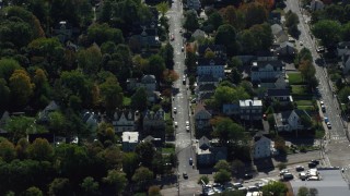 AX142_011 - 5.5K aerial stock footage flying over homes in small town, trees in autumn, Hyde Park, Massachusetts