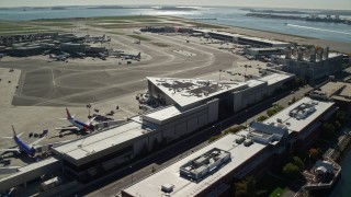 AX142_033 - 5.5K aerial stock footage flying by parked planes, Logan International Airport, Boston, Massachusetts