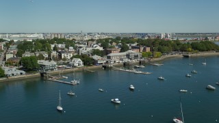AX142_213 - 5.5K aerial stock footage flying by piers, anchored boats, South Boston, Massachusetts