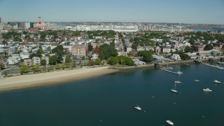 AX142_245 - 5.5K aerial stock footage flying by coastal community, beach, reveal piers, boats, South Boston, Massachusetts
