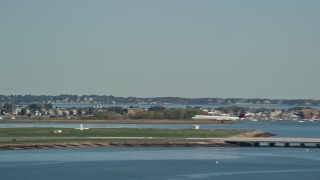 AX142_287 - 5.5K aerial stock footage tracking a commercial airplane landing, Logan International Airport, Massachusetts