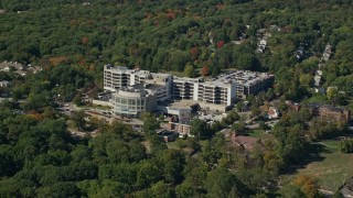 AX142_313E - 5.5K aerial stock footage flying by Faulkner Hospital, colorful trees, autumn, Jamaica Plain, Massachusetts