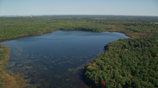 AX143_001E - 5.5K aerial stock footage approaching and flying over Ponkapoag Pond, autumn, Canton, Massachusetts