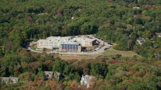 AX143_021 - 5.5K aerial stock footage flying by East Elementary, small town, trees, autumn, Hingham, Massachusetts