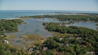 AX143_024E - 5.5K aerial stock footage flying over forest, approach small coastal community, autumn, Cohasset, Massachusetts
