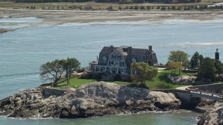 AX143_029 - 5.5K aerial stock footage flying by isolated upscale oceanfront home, Cohasset, Massachusetts