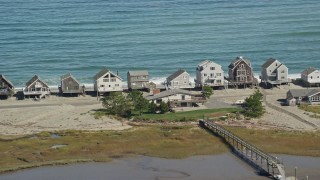 AX143_049 - 5.5K aerial stock footage flying by elevated oceanfront homes, Humarock, Massachusetts