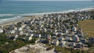 AX143_054E - 5.5K aerial stock footage flying by oceanfront homes, waves crashing, Marshfield, Massachusetts