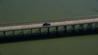 AX143_075E - 5.5K aerial stock footage orbiting Powder Point Bridge, tracking a black car, Duxbury, Massachusetts