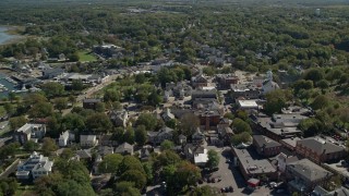 AX143_099E - 5.5K aerial stock footage flying over homes and shops, small town, Plymouth, Massachusetts