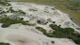 AX143_135 - 5.5K aerial stock footage flying over sand dunes, beach, approach isolated home, Barnstable, Massachusetts