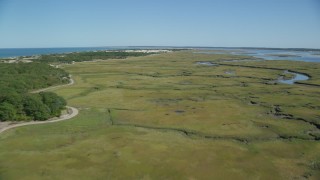 AX143_136 - 5.5K aerial stock footage flying over marshland, by isolated homes, coastal road, Barnstable, Massachusetts