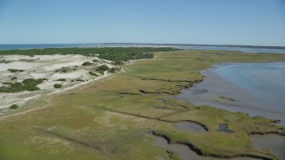 AX143_139 - 5.5K aerial stock footage of an isolated home, coastal road, marshland, sand dunes, Barnstable, Massachusetts