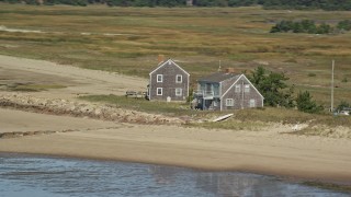 AX143_189 - 5.5K aerial stock footage flying by isolated beachfront homes, Cape Cod, Eastham, Massachusetts