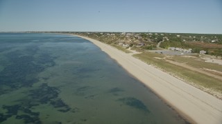 AX143_204E - 5.5K aerial stock footage flying over beach, inlet, pan to oceanfront homes in Cape Cod, Truro, Massachusetts