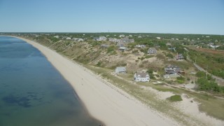 AX143_207 - 5.5K aerial stock footage flying by the beach and hilltop homes with ocean views, Truro, Massachusetts