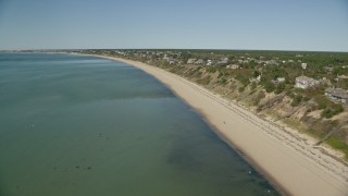 AX143_211 - 5.5K aerial stock footage flying over beach, approaching homes with ocean views, Truro, Massachusetts