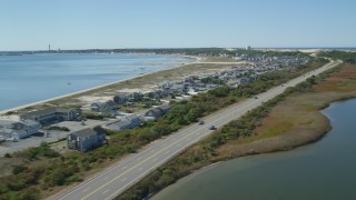 AX143_217 - 5.5K aerial stock footage flying by beachfront homes, Highway 6, coastal road, Truro, Massachusetts