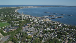 AX143_237 - 5.5K stock footage aerial video orbiting small coastal town, Pilgrim Monument, piers, Provincetown, Massachusetts