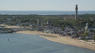 AX143_241E - 5.5K aerial stock footage orbiting small coastal town, reveal Pilgrim Monument, Provincetown, Massachusetts