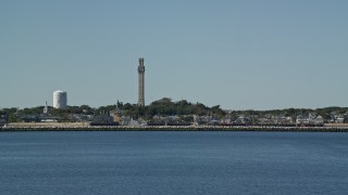 AX143_244E - 5.5K aerial stock footage orbiting sailing boat, revealing Pilgrim Monument and Provincetown, Massachusetts